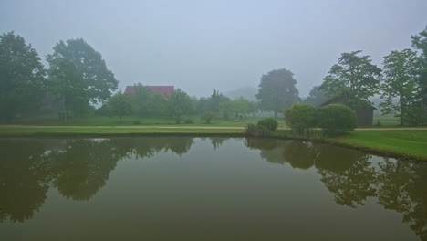 Vista-De-Lapso-De-Tiempo-Del-Estanque-Marrón-En-El-Parque-En-Un-Día-Soleado-Que-Se-Vuelve-Un-Día-Gris-Sombrío-Con-Niebla-Y-Niebla