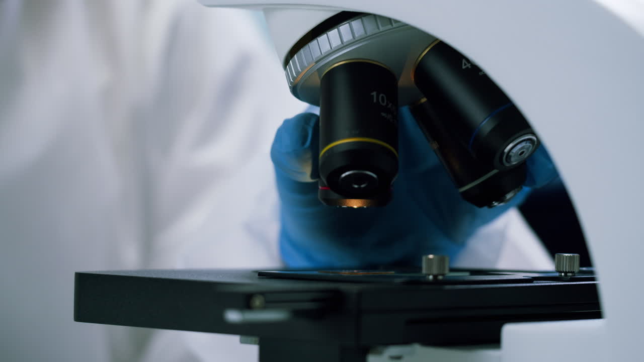 Close-up of Microscope Being Adjusted in a Laboratory