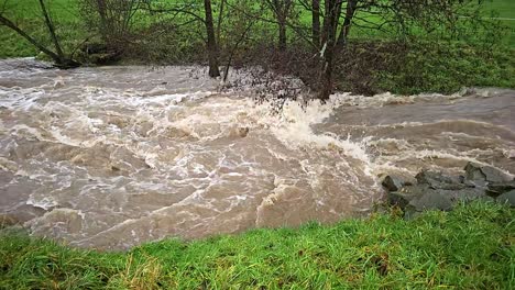Dirty flood water flowing fast in the river, abstract close-up, super slow motion video