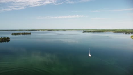 Velero-De-Aguas-Tranquilas-De-Verano-Por-La-Mañana,-Vista-Aérea,-Hessel,-Michigan