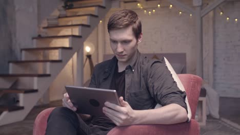 man using tablet in a living room