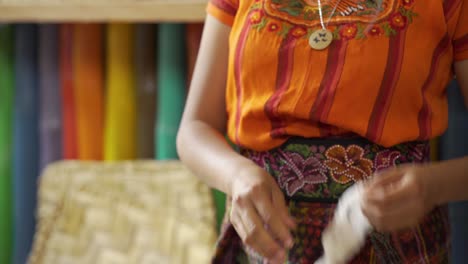 hermoso primer plano de una tejedora maya separa las semillas de las fibras de algodón a mano