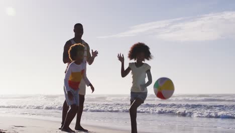 Afroamerikanischer-Vater-Und-Seine-Kinder-Spielen-Mit-Einem-Ball-Am-Strand