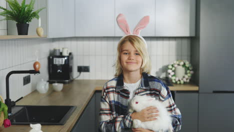 boy holding easter rabbit in kitchen