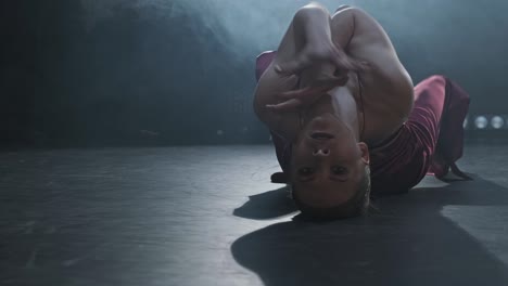 graceful female dancing in studio with smoke and spotlight. silhouette of woman