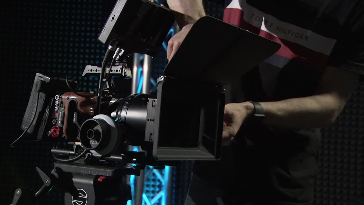 누군가 촬영을 위해 빨간색 시네마 카메라를 redy로 만들고 있습니다.