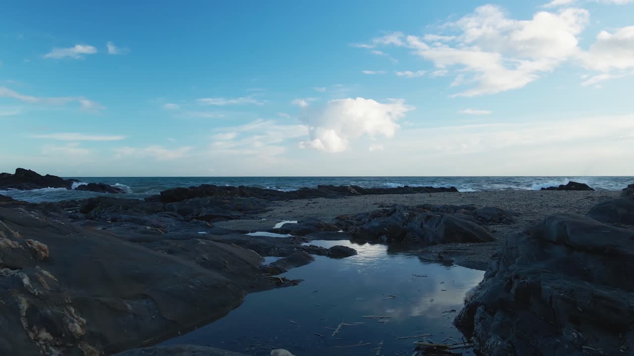 pequeño estanque en la playa rocosa y vacía