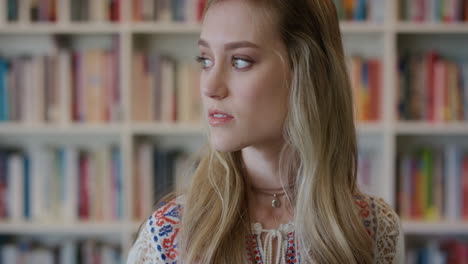 portrait young beautiful blonde woman student pensive turns head looking at camera cute female caucasian girl in bookshelf background