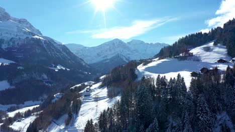 Amazing-drone-flight-of-a-stunning-alpine-valley,-village-and-snow-covered-mountain-peaks-in-Champery,-Switzerland