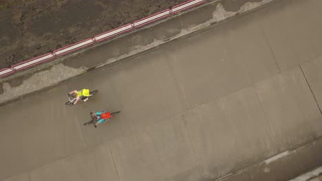 Luftaufnahme-Von-Oben-Von-Zwei-Radfahrern,-Die-Während-Des-Tura-Cu-Copaci-Rennens-über-Den-Damm-Am-Colibita-Staudamm-In-Rumänien-Radeln