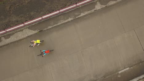 vista aérea superior de dos ciclistas vendiendo sobre la presa en la presa colibita en rumania durante la carrera tura cu copaci