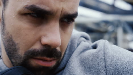 close-up view of the sweaty face of the male boxer during a training outdoors an abandoned factory on a cloudy morning