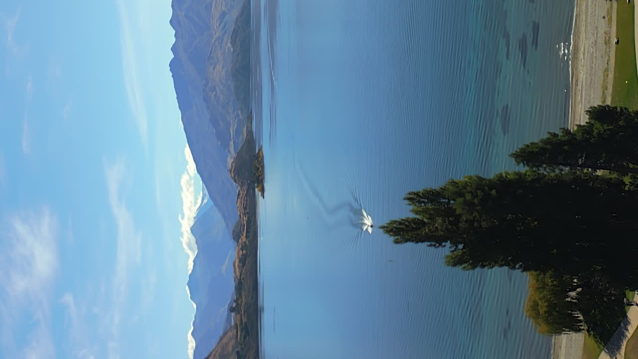 Lake Wānaka as seen from the resort town of Wanaka, South Island, New Zealand - ascending, vertical aerial reveal