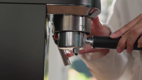 woman installs portafilter on coffee machine closeup. lady assembles coffeemaker to prepare hot black drink at home. appliance of caffeine beverage