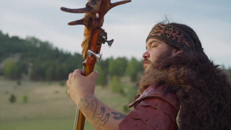 obese bearded guy in leather clothes plays ikili at fest