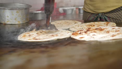 cocinando roti chapati en una sartén grande ,