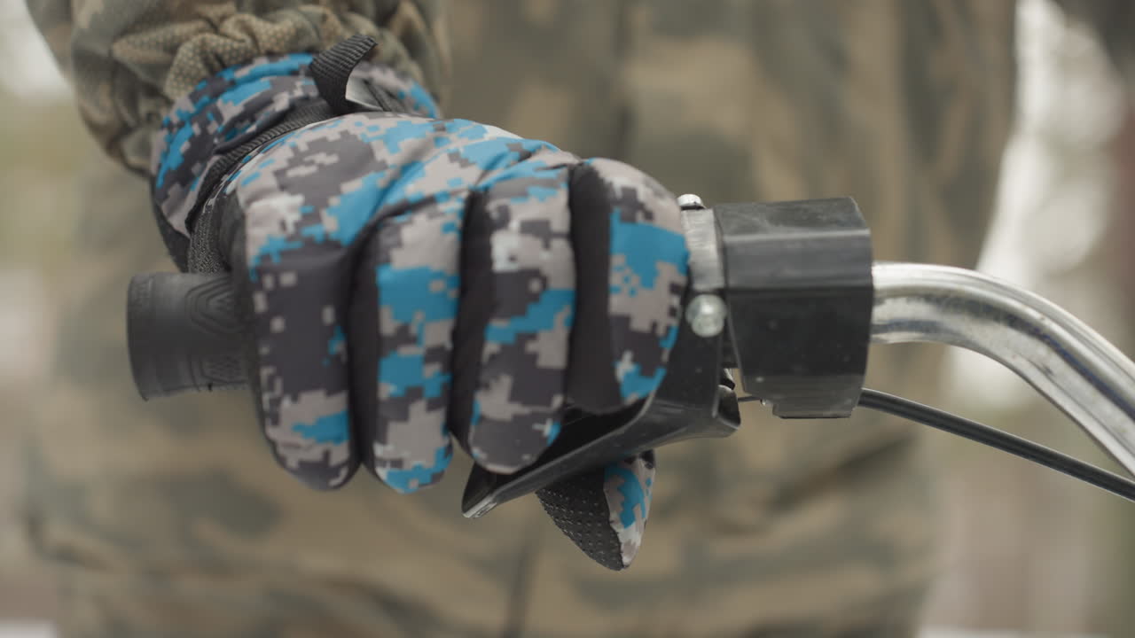 Close-up van een gehandschoende hand op het gashendel van een ATV, camouflagejack, precieze draai aan de handgreep, bevroren bos op de achtergrond, slowmotion focus op het bedieningsmechanisme, bestuurder test de gasresponsiviteit tijdens een winterparcours.