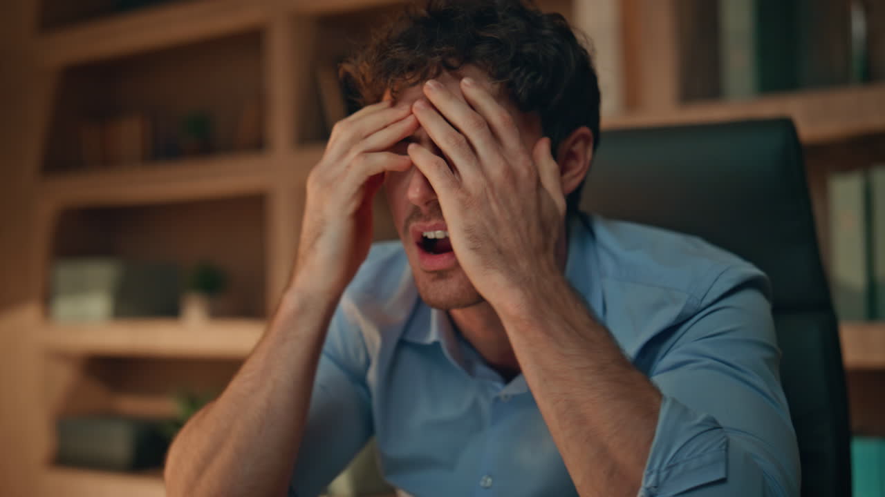 Worried freelancer looking smartphone message hiding face in palms close up.