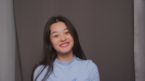 Young-Woman-In-Photo-Booth-Having-Fun-Posing-For-Portrait-And-Pulling-Faces-Shot-In-Real-Time