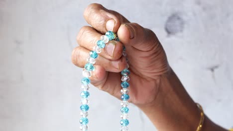 woman holding a beaded necklace