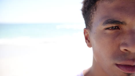 A-young-biracial-man-with-short-hair-gazes-into-the-distance,-with-copy-space