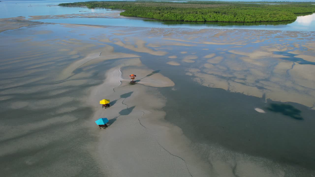 sombrillas de cenador tropical en la playa de arena durante la baja