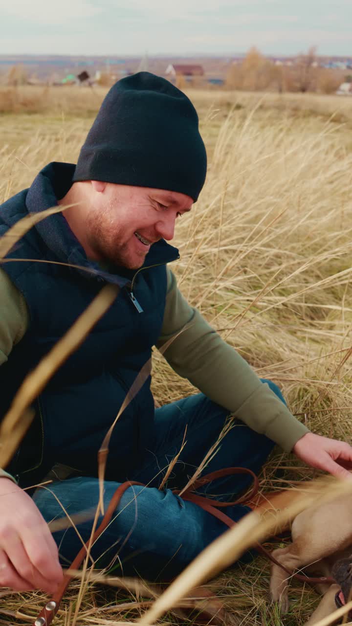A joyful moment captured between a person and their dog as they enjoy a serene day in a grassy field, showcasing the bond and companionship shared amidst nature's beauty and tranquility