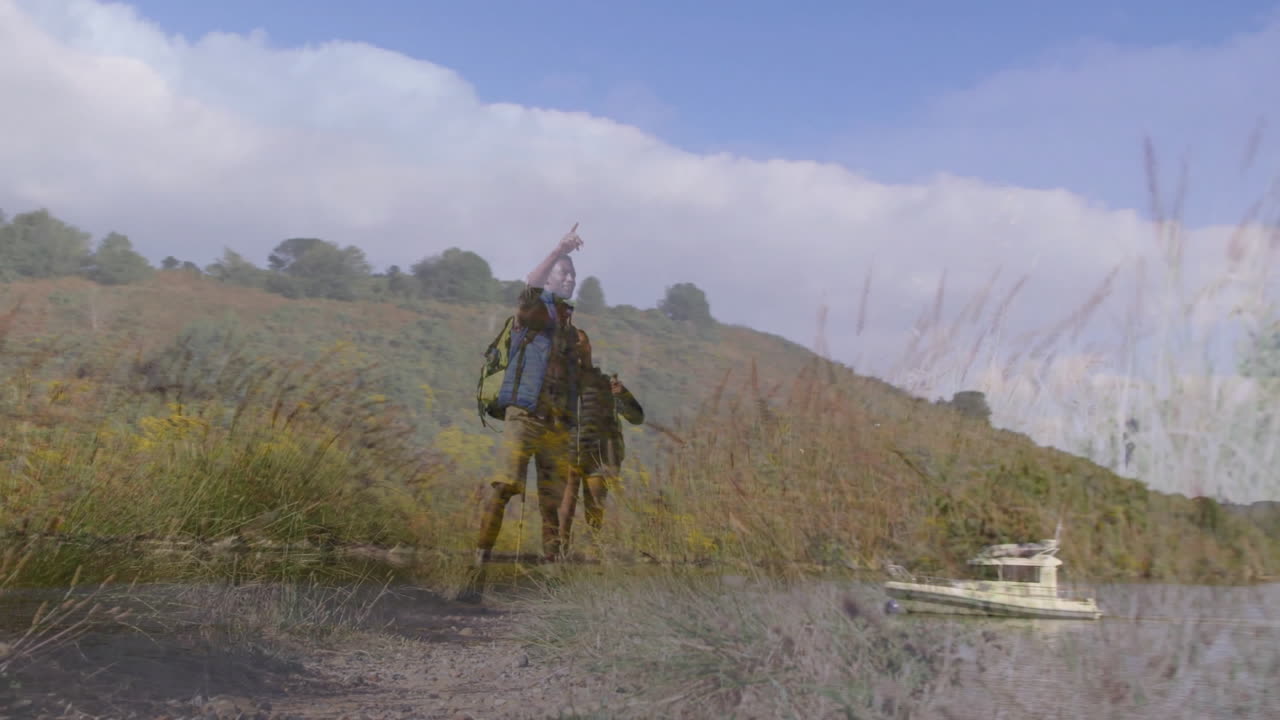 two hikers carrying backpack using poles on riverside trail in travel ad, with motion map icons