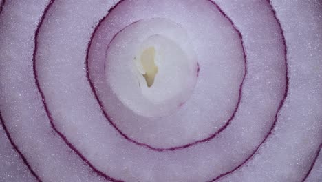 textura anillos de cebolla roja girando, vista superior de primer plano. alimento saludable cosechado fondo con verduras ricas en vitaminas. cebolla española roja dulce macro disparo. fondo de alimento primer plano cebolla púrpura cortada en rodajas