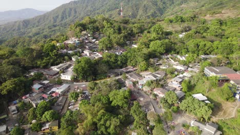 una foto aérea de minca, colombia, con una pequeña aldea enclavada en exuberantes montañas verdes