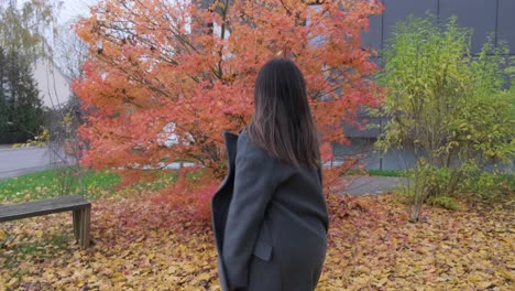 나뭇잎 위에 가을 시즌에 걷고 춤추는 소녀