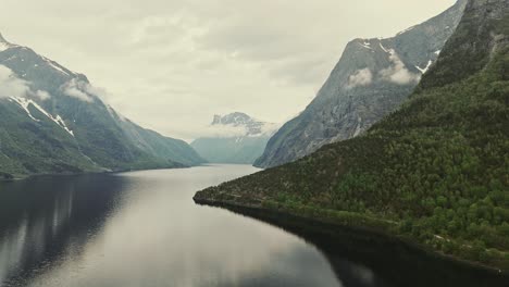 Vista-Aérea-Sobre-El-Lago-Eikesdalsvatnet-En-Noruega-Con-Montañas-Alrededor-Durante-El-Día-Nublado,-Paisaje-Junto-Al-Lago