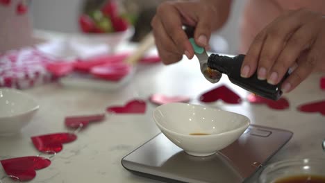 Adding-a-teaspoon-of-vanilla-extract-into-a-small-white-bowl-making-a-special-valentine's-day-cake-vegan-chocolate-cake-eggless-plant-based-dairy-free