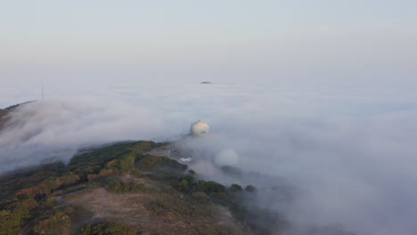 densa nube de niebla que cubre la colina con varias estructuras en la noche