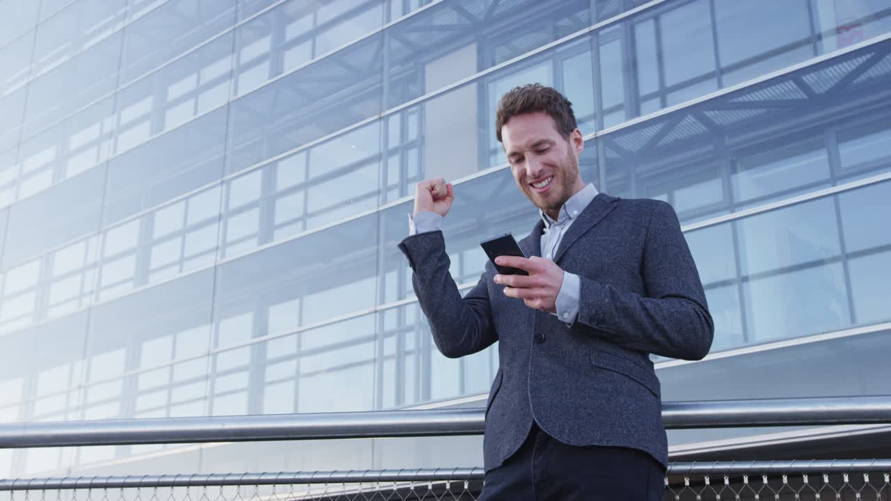 éxito y logro - feliz hombre de negocios aplaudiendo mirando el teléfono celular