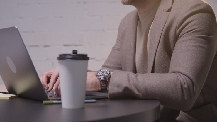 Serio uomo d'affari che analizza dati usando un computer portatile durante una riunione di lavoro