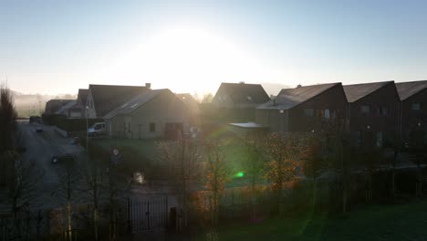 Aufsteigender-Flug-Mit-Untergehender-Sonne-Neben-Häusern-Von-Westouter-In-Westflandern-In-Belgien