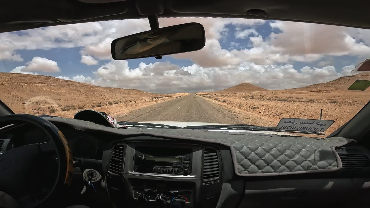 punto de vista de la cabina del coche durante el viaje a lo largo del desierto de túnez en túnez en un día nublado