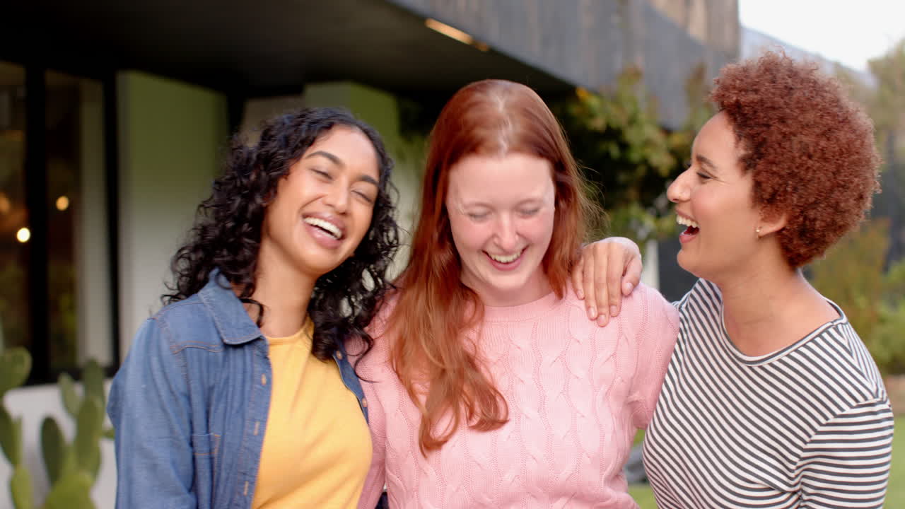 Laughing and embracing, diverse female friends enjoying outdoor time together