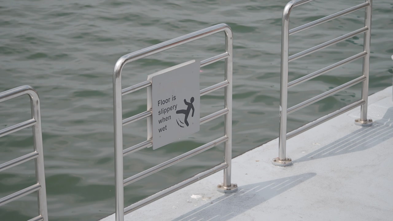 Slippery Floor Warning Sign on a Dock by the Water