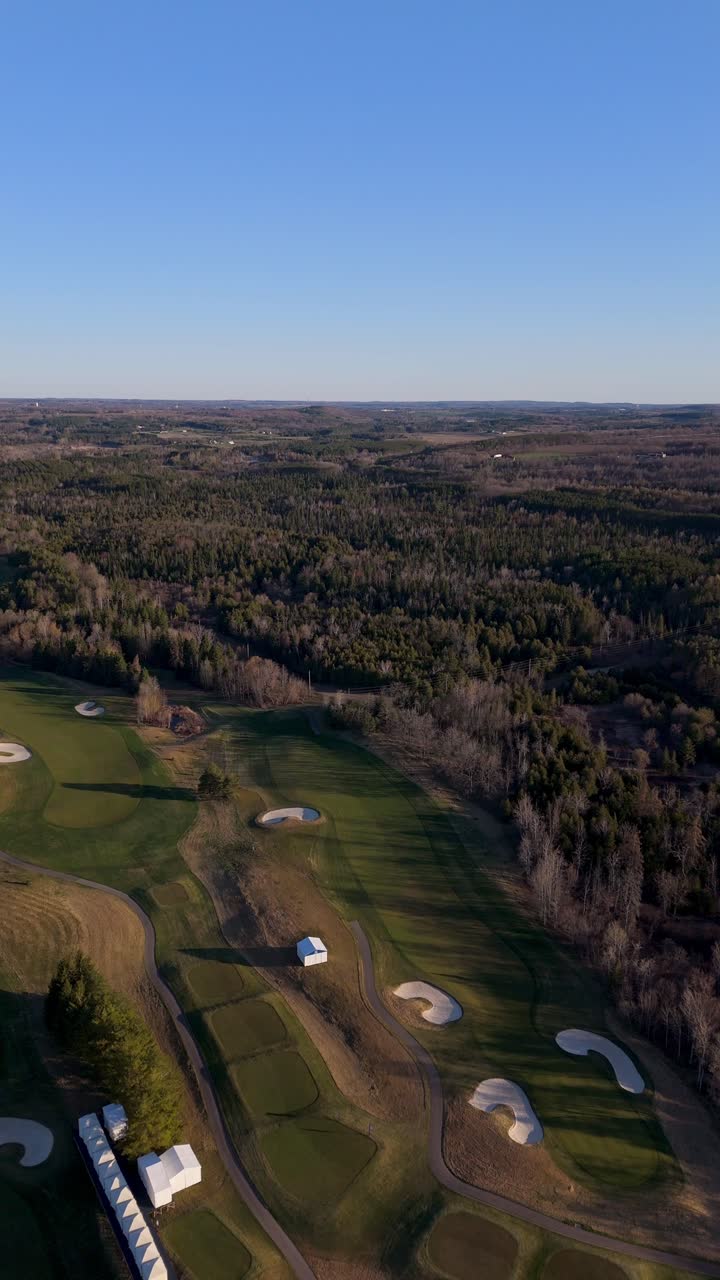 Vertical drone overview of TPC Toronto Osprey Valley Golf Course with wide green fairways and trees, establishing with long shadows