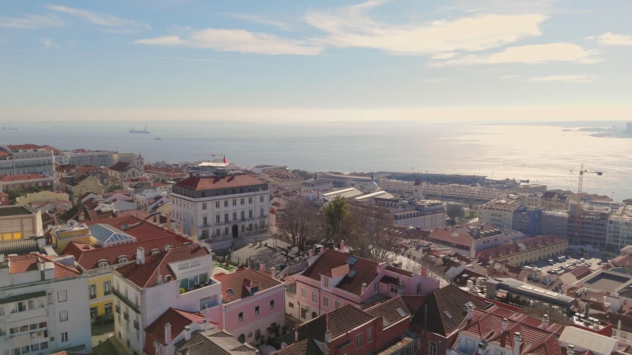 Ascesa aerea sopra case ed edifici a Lisbona, Portogallo, per rivelare la foce del fiume Tago