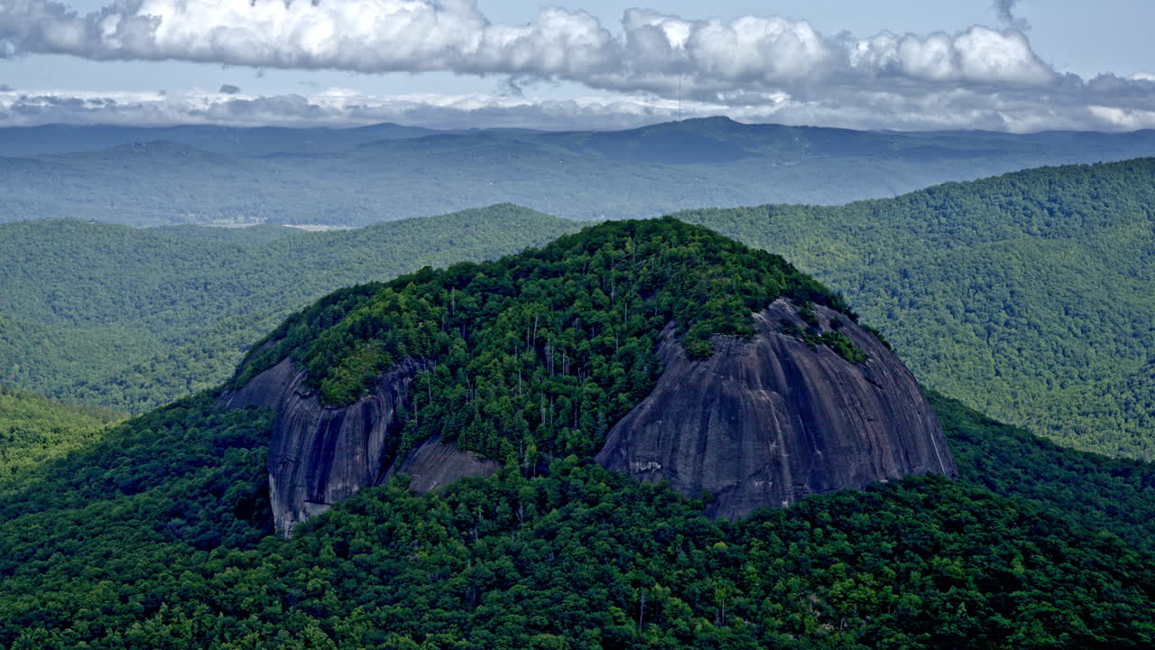 Aerial drone view of a massive solitary mountain rising distinct from the surrounding range