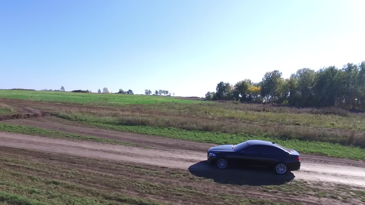 시골 풍경 을 가로질러  도로 를 달리는 검은 차