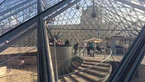 people entering louvre museum under glass pyramid