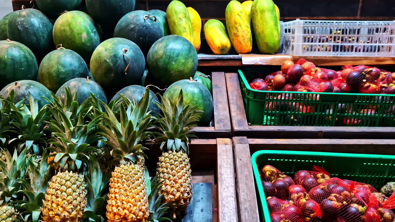 Una colorata esposizione di angurie, ananas, papaie e mangostani disposti in un vivace mercato di frutta locale sull'isola di Gili Trawangan, Indonesia.