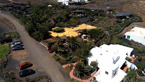 yellow rooftop of small luxury villa in lanzarote island, aerial fly away view