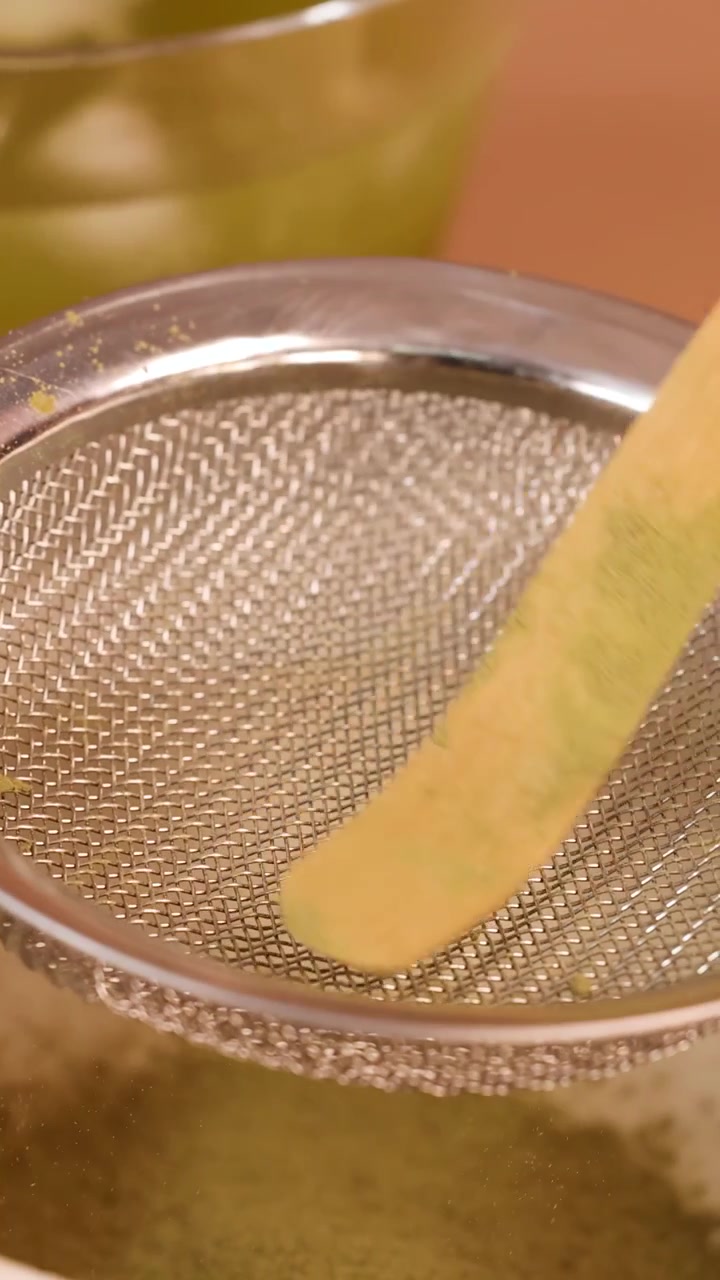 Primo piano di polvere di matcha tradizionale setacciata in una ciotola di ceramica con inquadratura stabile