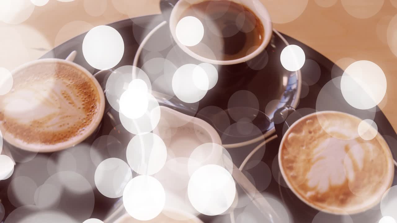 Zu Beginn dreht sich ein Tablett mit vier Tassen und einem Krug, und Bokeh schwebt, um den Caféservice hervorzuheben