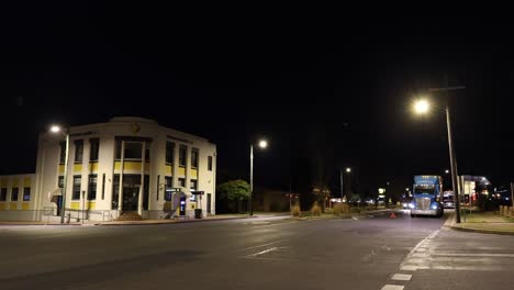 los vehículos pasan por una intersección iluminada por la noche